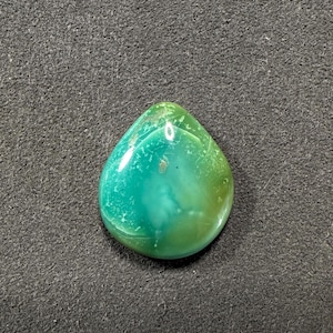 May include: A teardrop-shaped green and blue gemstone cabochon with a light green and white pattern.