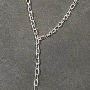 Pode incluir: Um colar de corrente de prata com fecho de lagosta. A corrente &eacute; feita de pequenos elos ovais.