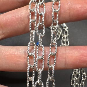 Pode incluir: Tr&ecirc;s correntes de prata com um design de elo oval texturizado.
