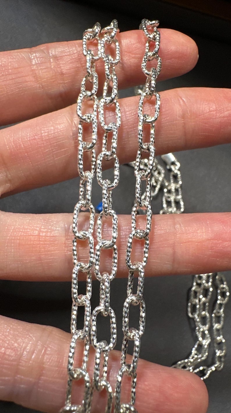 Pode incluir: Tr&ecirc;s correntes de prata com um design de elo oval texturizado.