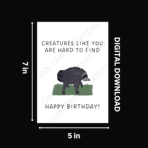 May include: A white rectangular greeting card measuring 12.7 cm by 17.8 cm featuring a black and grey raccoon illustration on green grass. The text reads: CREATURES LIKE YOU ARE HARD TO FIND HAPPY BIRTHDAY! The card is labelled as a DIGITAL DOWNLOAD.