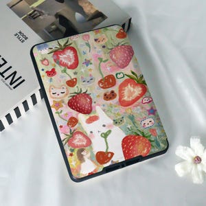 May include: A colourful phone case featuring a white rabbit, strawberries, cherries and other whimsical illustrations.
