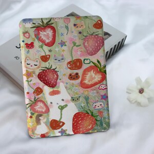 May include: A white phone case featuring a colourful illustration of strawberries, cherries, flowers, and cute animals. The background is a light green and pink watercolour wash.