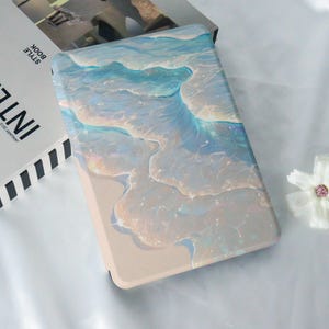 Könnte beinhalten: Ein hellblaues und weißes abstraktes Design mit einem wirbelnden Muster auf beigefarbenem Hintergrund. Das Design ähnelt Wellen oder Wasser.