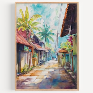 Op de afbeelding: Aquarel schilderij van een tropische straatscène. Het kunstwerk toont een smalle straat met aan weerszijden gebouwen met rode pannendaken en palmbomen. De lucht is een mix van blauw en wit en de scène wordt badend in zonlicht.
