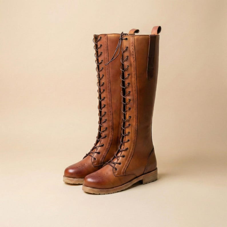 Peut inclure: Deux bottes hautes en cuir marron avec un design &agrave; lacets. Les bottes ont un style classique, d'inspiration &eacute;questre, avec un bout arrondi et une semelle robuste. Le cuir a une teinte riche et chaude. La hauteur des bottes est d'environ 40 cm.