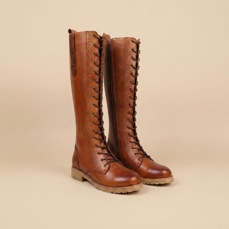 Peut inclure: Une paire de bottes hautes en cuir marron avec un la&ccedil;age et une fermeture &eacute;clair lat&eacute;rale. Les bottes ont un style classique et vintage avec un petit talon et une semelle textur&eacute;e. Les bottes mesurent environ 40 cm de haut.