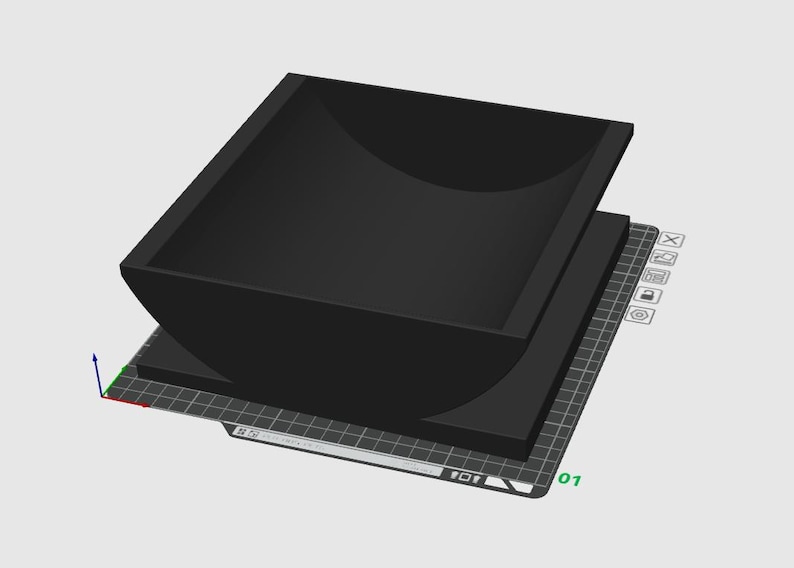 May include: A black, square-shaped container with rounded corners, sitting atop a flat, rectangular base. The container has a curved interior and is displayed on a grid-like surface, suggesting a 3D model or design.