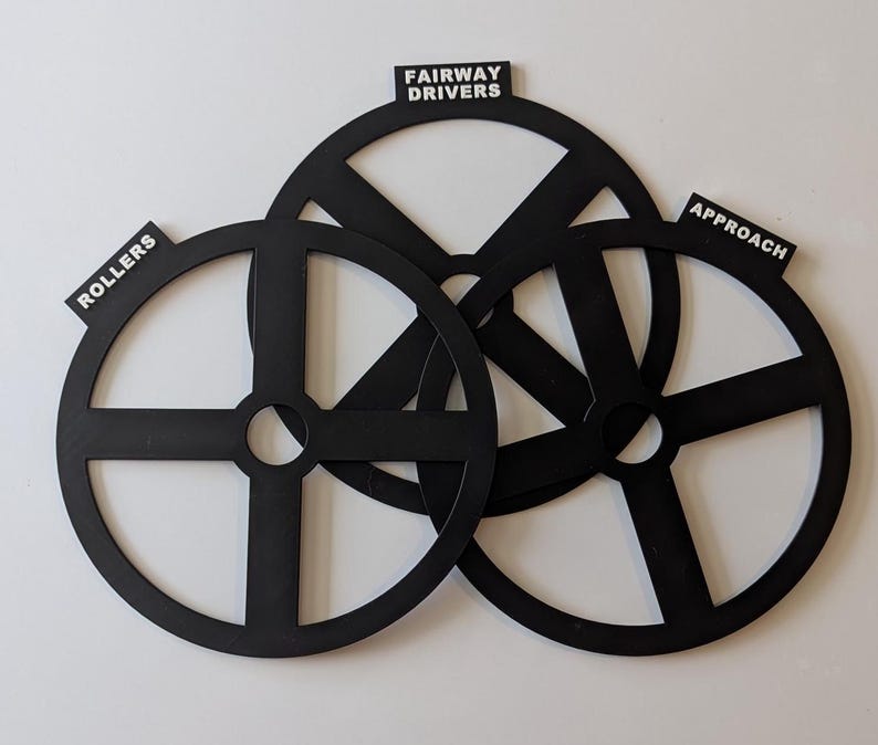 May include: Three black plastic golf putting practice aids with labels: "Rollers", "Fairway Drivers", and "Approach".