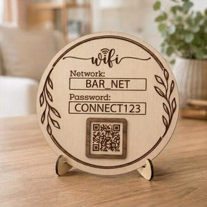 May include: A circular light-colored wooden sign featuring the text "wifi", "Network: BAR_NET", and "Password: CONNECT123". The sign includes a central QR code, decorative leaf patterns on the sides, and is supported by a small wooden stand.