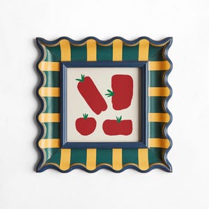 Peut inclure: Un cadre rayé bleu et jaune avec un bord festonné. Le cadre contient un passe-partout blanc avec une image de quatre tomates rouges.
