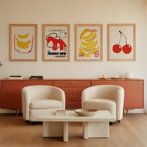 Puede incluir: Una sala de estar con cuatro cuadros enmarcados con ilustraciones de frutas: plátanos, cerezas y un caballo rojo. La habitación incluye un mueble color coral, dos sillones color crema y una mesa de centro blanca. El texto "THANK YOU" es visible.