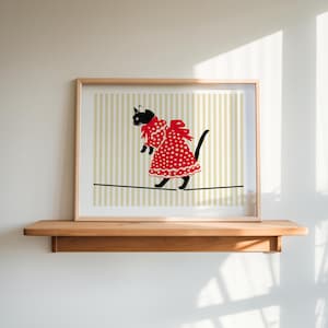 May include: A black cat wearing a red polka dot dress walks on a tightrope. The background is a striped pattern in beige and light brown.