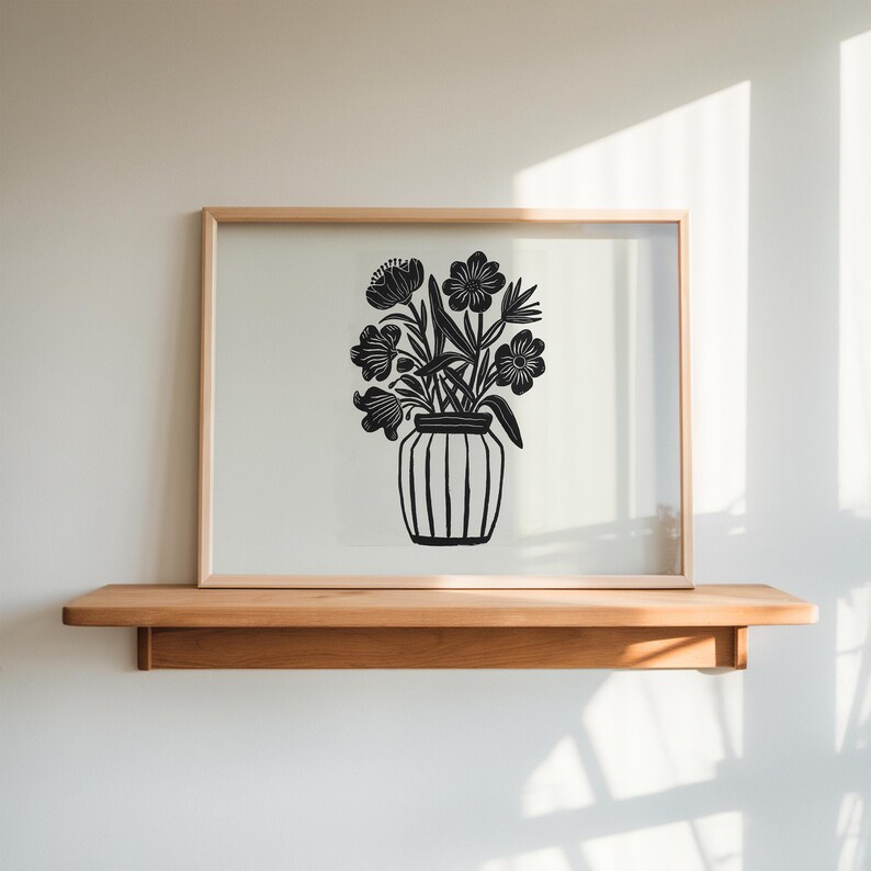 May include: A black and white print of a vase with flowers. The vase is striped and the flowers are stylized.