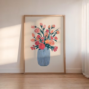 Puede incluir: Una impresión enmarcada de un arreglo floral colorido en un jarrón azul. Las flores son rosas, naranjas y amarillas, y el jarrón tiene un patrón texturizado.