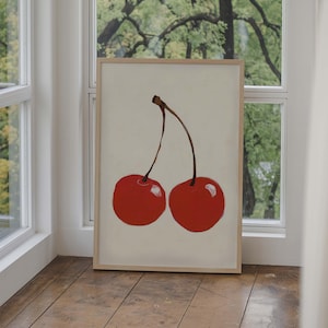 May include: A framed print of a painting of two red cherries with stems on a white background.