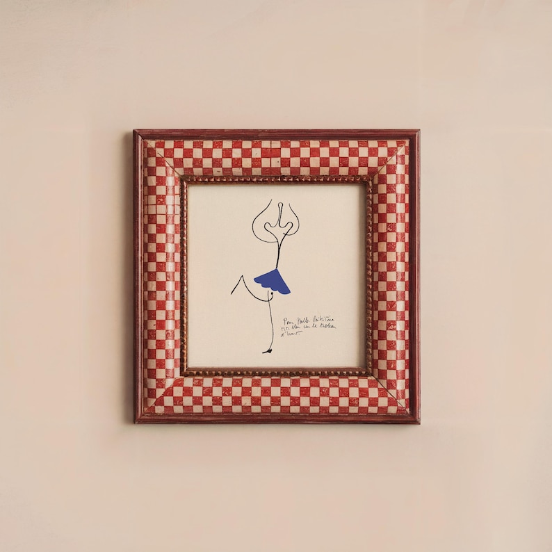 May include: A framed drawing of a stick figure wearing a blue skirt. The frame is red and white checkered. The drawing is titled "Pam Bulloch Atkins 1973" and signed "Le R&ecirc;ve d'Amour".