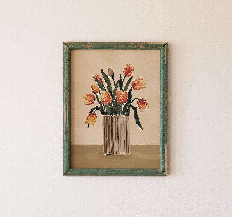 May include: A framed print of a still life featuring a bouquet of orange and red tulips in a striped vase. The background is a light beige color.