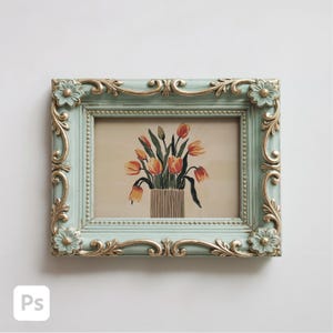 May include: Rectangular picture frame with a light blue and gold ornate design. The frame holds a picture of orange and yellow tulips in a vase. The frame has floral corner accents and a detailed border.