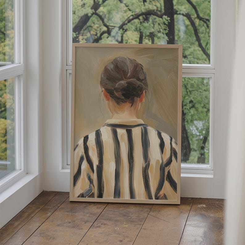 May include: A framed painting of a person wearing a striped shirt. The person is facing away from the viewer and has their hair pulled back in a bun. The painting is set against a light brown background.