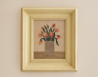 May include: A framed print of a still life painting featuring a bouquet of orange and yellow tulips in a brown and white striped vase. The painting is set against a light brown background.