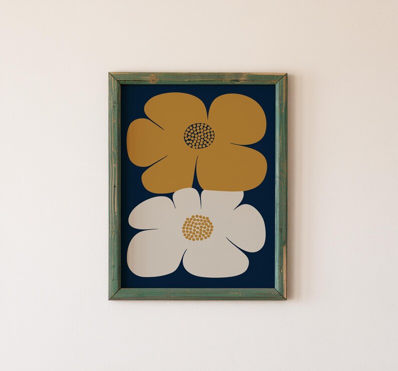 May include: A framed print featuring two large stylized flowers. The top flower is mustard yellow and the bottom flower is white with a light gray center. The background is a dark blue.