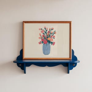 Könnte beinhalten: Ein gerahmter Druck eines bunten Blumenarrangements in einer blau-weiß gestreiften Vase. Die Blumen sind rosa, orange und gelb. Der Druck ist auf weißem Hintergrund und in einem naturfarbenen Holzrahmen gerahmt.