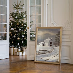 May include: A framed winter scene painting of a white farmhouse with a red roof and a snow-covered field. The painting is in a gold frame and is hanging on a white wall.