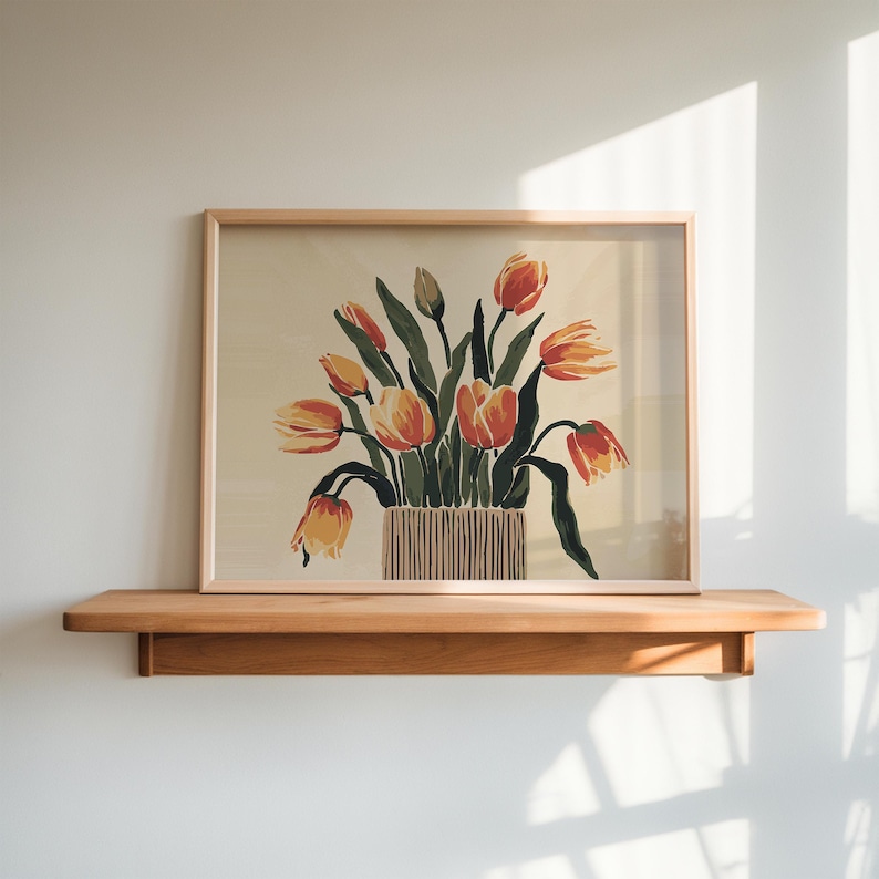 May include: A framed print of a still life featuring a bouquet of orange and yellow tulips in a brown and white striped vase. The tulips are arranged in a vase with green leaves and stems.