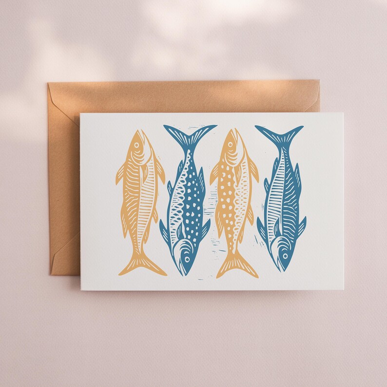May include: A greeting card featuring four stylized fish illustrations. Two fish are yellow, and two are blue, all against a white background. The card is accompanied by a brown envelope, perfect for sending a nautical-themed message.