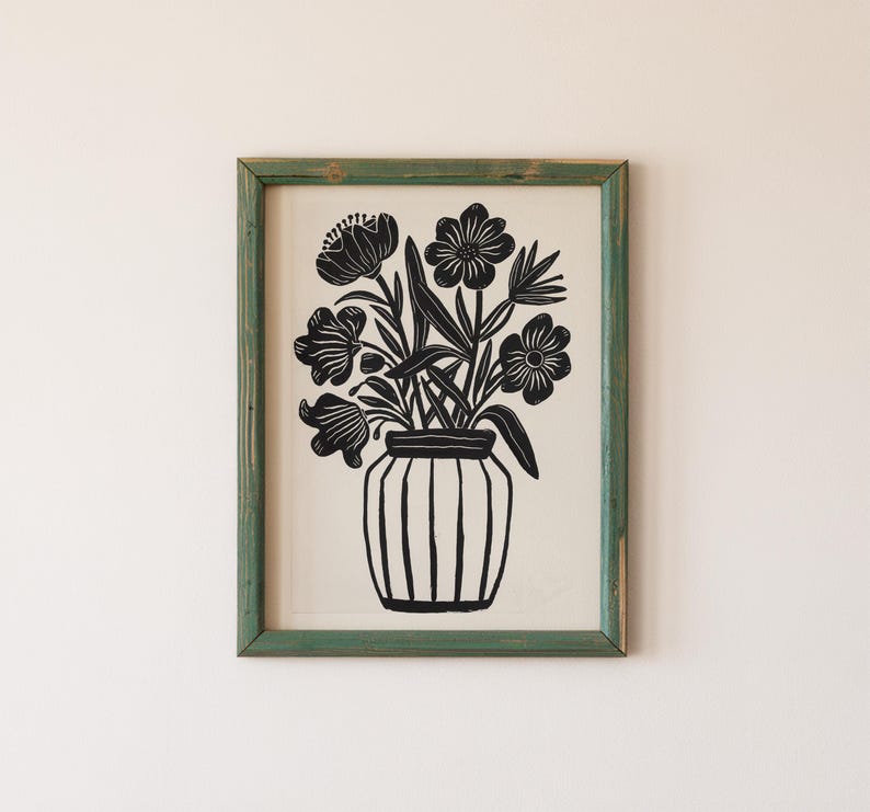May include: Black and white print of a vase with flowers. The vase is a simple, cylindrical shape with vertical lines. The flowers are stylized and have a simple, geometric design.