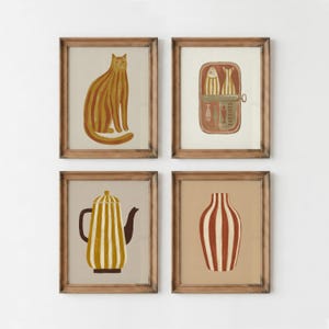 May include: A set of four framed wall art prints featuring a mustard yellow striped cat, a tin of sardines with the text SARDINES, a mustard yellow striped teapot, and a terracotta and white striped vase, all enclosed in matching wooden frames.