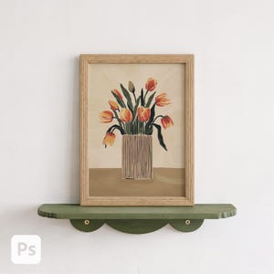 May include: A framed art print featuring a vase of orange tulips. The artwork is in a light wooden frame and rests on a green scalloped shelf. The background is a neutral color, and the overall aesthetic is minimalist and modern.