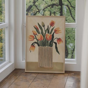 May include: A framed painting of a bouquet of orange and yellow tulips in a striped vase. The background is a light beige color.