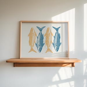May include: A framed print of four stylized fish in blue and yellow colors. The fish are arranged in a row, with their tails facing the viewer. The print is set against a white background.