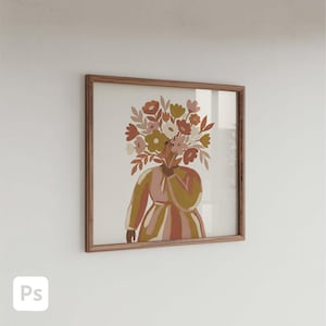 Puede incluir: Una impresión artística enmarcada que presenta una figura con una cabeza floral. La obra de arte tiene una paleta de colores cálidos de rosa, marrón y amarillo. El marco es de madera y está colgado en una pared blanca.