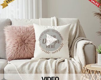 May include: A white throw pillow with a brown wreath design and the text "Your Design Here" on a white couch with a pink fuzzy pillow. The text "VIDEO Mockup" is at the bottom of the image.