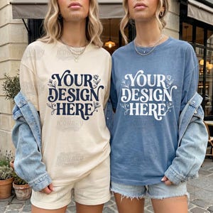 May include: Two women wearing matching outfits. One wears a cream-colored long-sleeve t-shirt and shorts, the other a blue t-shirt and denim shorts. Both shirts have the text "YOUR DESIGN HERE" in a decorative font.