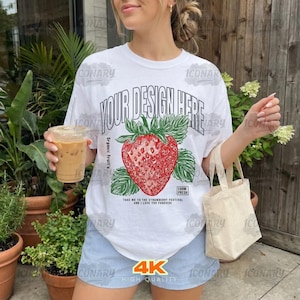 May include: White t-shirt with a large red strawberry graphic and the text "YOUR DESIGN HERE". The strawberry has green leaves and the words "Farm Fresh" are below it. The shirt also has the text "Take me to the strawberry festival and I love you forever!"