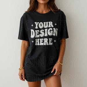 May include: A black oversized t-shirt with the text "YOUR DESIGN HERE" in white with a distressed, vintage look.