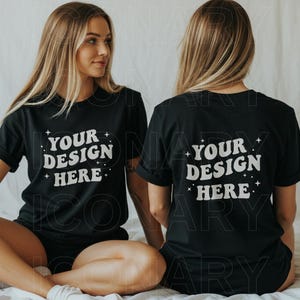 May include: Two people wearing black t-shirts with the text "Your Design Here" in white. The shirts are a blank canvas for customisation.