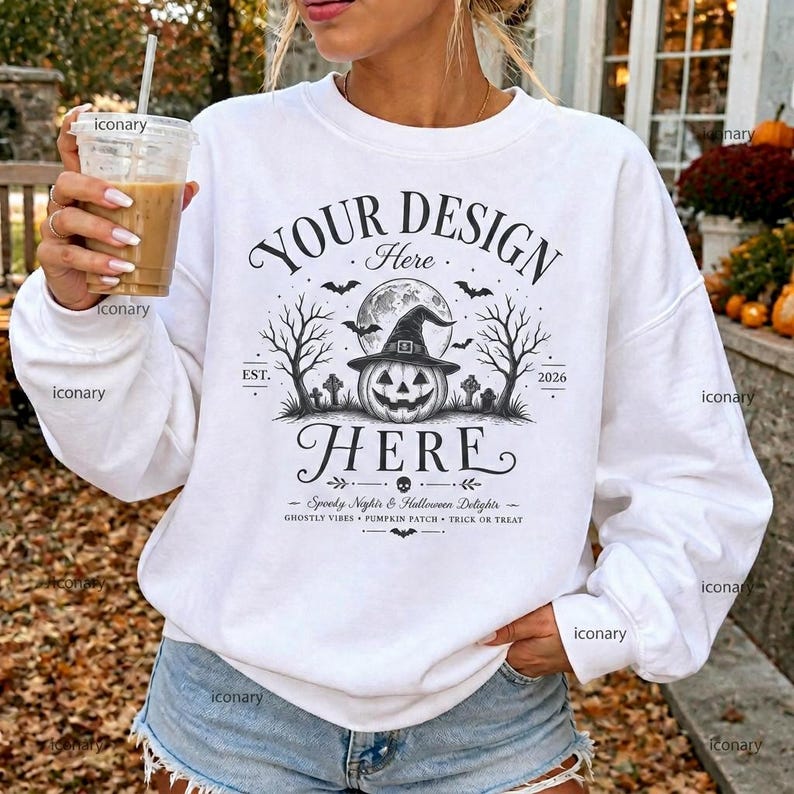 Puede incluir: Una sudadera blanca de manga larga con un estampado gr&aacute;fico negro de una calabaza con sombrero de bruja, rodeada de &aacute;rboles desnudos, murci&eacute;lagos y l&aacute;pidas. El texto dice YOUR DESIGN HERE, EST. 2026, Spooky Night & Halloween Delights.