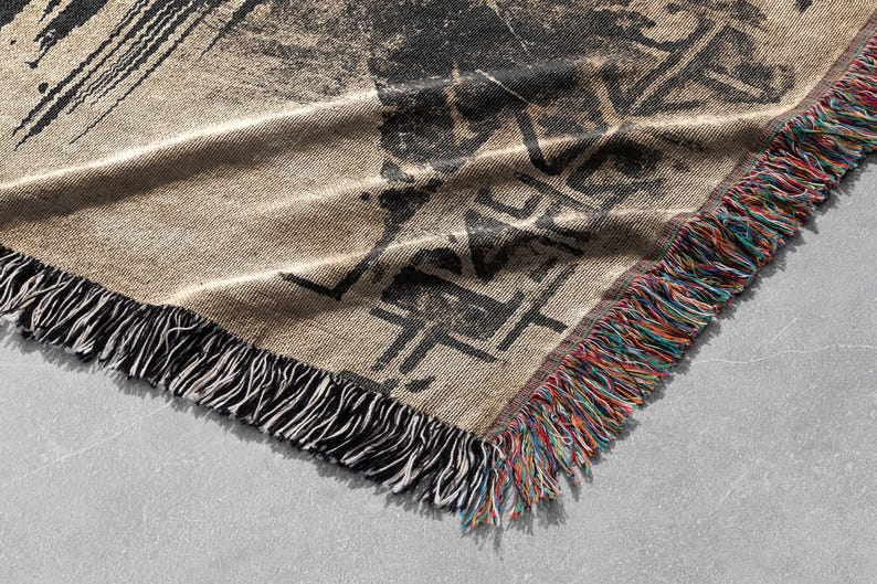 Pu&ograve; includere: Una coperta in tessuto intrecciato con un design astratto in bianco e nero e frange multicolori. La coperta &egrave; realizzata in un tessuto morbido e testurizzato.