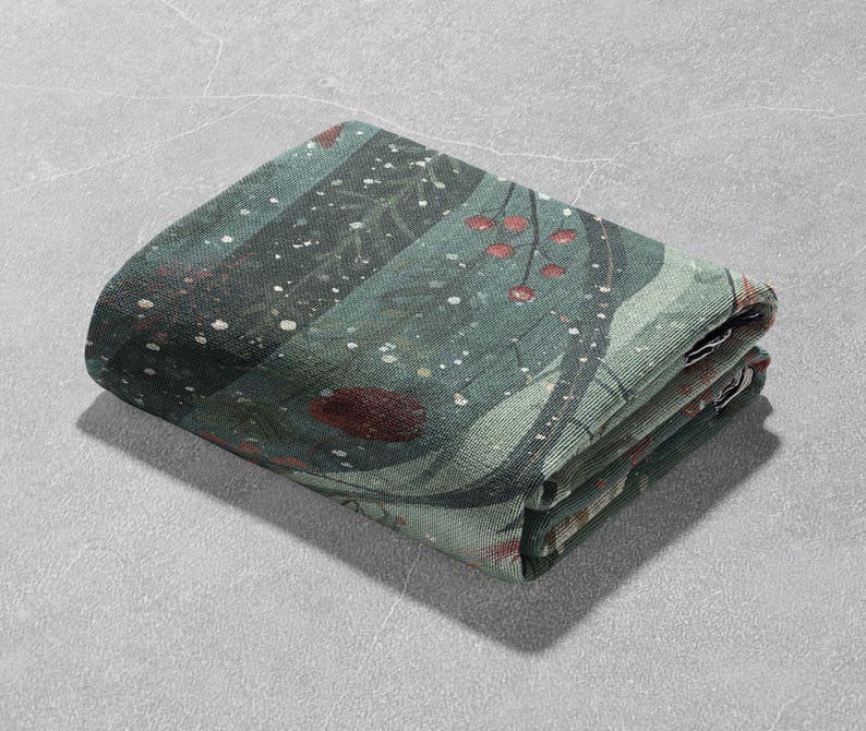 May include: Folded green and teal fabric with a nature-inspired design. The fabric features a pattern of branches, berries, and white speckles. The folded edges reveal the layers of the fabric.