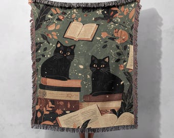Geweven deken met zwarte katten en bibliotheekmotief – 100% katoen, knusse heksenachtige plaid met boeken en herfstbladeren, donkere academische stijl.