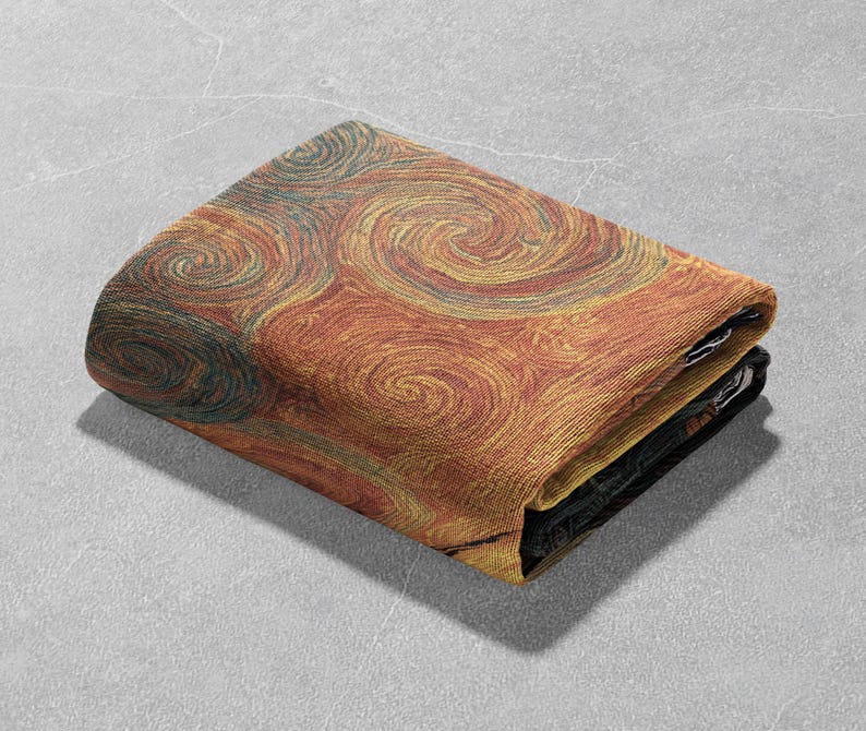 May include: Folded blanket featuring a swirling pattern in shades of orange, yellow, and teal. The design resembles brushstrokes or a stylized representation of a natural phenomenon. The blanket is folded neatly, showcasing the detailed texture and color variations.