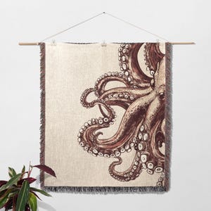 May include: A woven tapestry wall hanging featuring a detailed illustration of an octopus with tentacles in shades of brown and cream against a beige background.