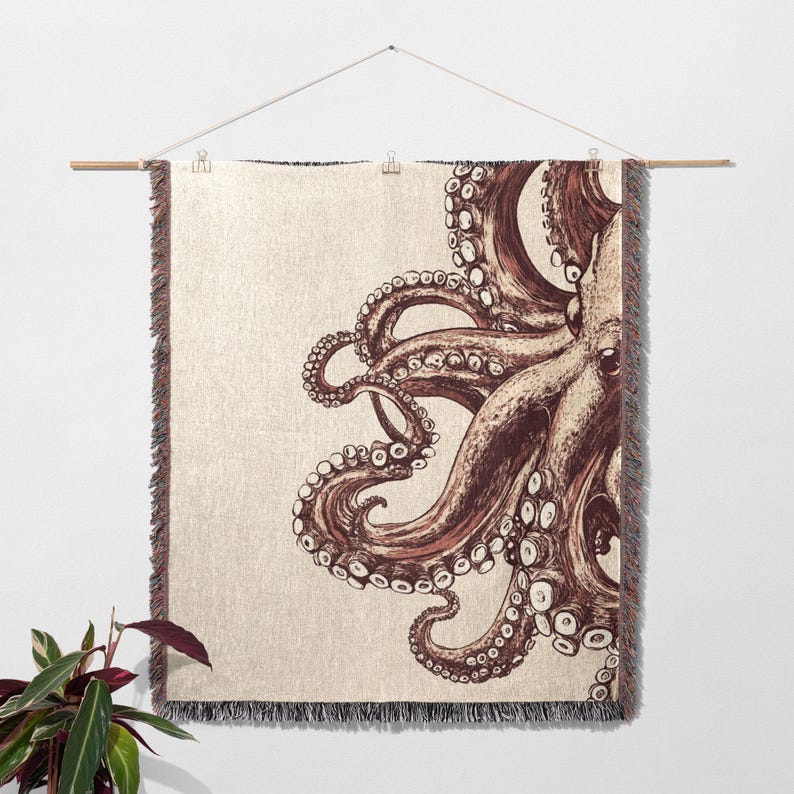 May include: A woven tapestry wall hanging featuring a detailed illustration of an octopus with tentacles in shades of brown and cream against a beige background.