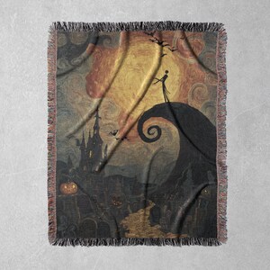 May include: Woven throw blanket featuring a spooky scene with a silhouetted figure on a hill, a swirling spiral, and a haunted house. The color palette includes shades of orange, yellow, and black, with a fringed edge.