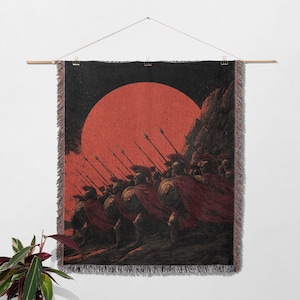 May include: A woven wall tapestry depicting a line of ancient warriors in red capes and helmets, holding spears. A large red sun is in the background. The tapestry is hung from a wooden rod.